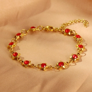 Detail of gold-plated star bracelet featuring red zircon stones and lobster clasp