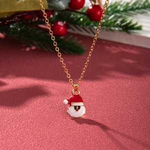 Detail of a Christmas necklace featuring a Santa Claus pendant with a golden chain on red