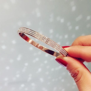 Close-up of rose gold bangle featuring three rows of sparkling pavé crystals for women