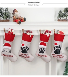 Set of four pet-themed Christmas stockings with paw prints hanging on a white mantel