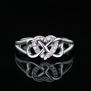 Macro detail of silver ring featuring interlocking hearts with pink pave-set zircons