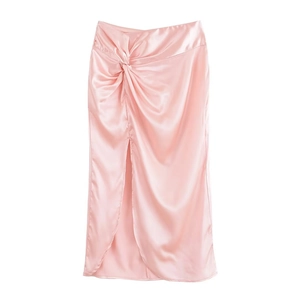 Detail eines rosa Satin-Midirocks mit Knotendesign an der Taille und Beinschlitz