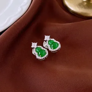 Elegant green gourd earrings with zircon inlay on luxury dark silk fabric background