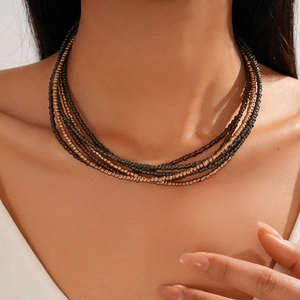 Bohemian multilayer glass beaded necklace in bronze and dark brown tones worn by model