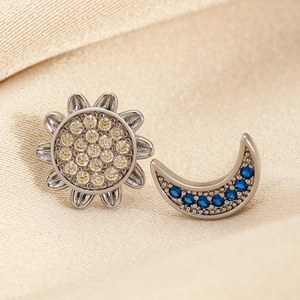 Celestial sun and moon stud earrings with blue and yellow crystals on beige silk