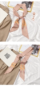 Detail of pink and orange geometric silk scarf tied in a bow on a beige blazer