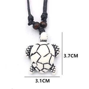 Resin sea turtle necklace with black woven cord and size markings of 3.1cm x 3.7cm