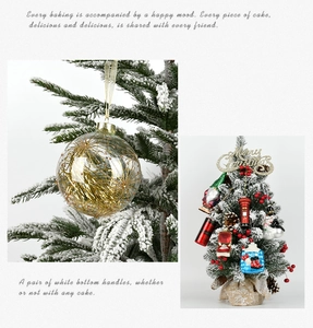 Detail of clear Christmas ball with gold glitter and mini tree with festive ornaments