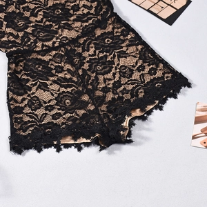 Close-up of black floral lace texture with skin-toned lining on a slim-fit romper