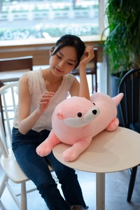 Detailed view of plush pink otter doll shell with soft long faux fur in a warm cafe setting