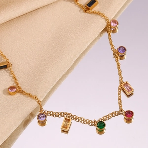 Detailed macro of 18K gold plated necklace with colorful zircon on a satin surface