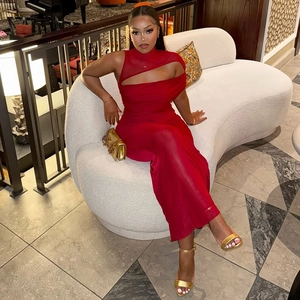 Rotes figurbetontes langes Kleid mit Cut-Outs und Mesh-Einsatz auf Modell auf Sofa sitzend