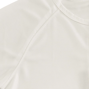 Detail of white waffle knit fabric showing reinforced stitching and breathable mesh texture
