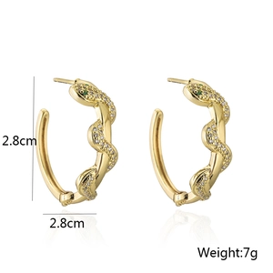 Detail of 18K gold snake hoop earring with green gemstone eyes and micro-set zircons