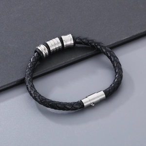 Detail of black braided leather bracelet with silver magnetic clasp and metal beads