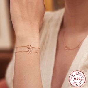 Elegant 925 sterling silver minimalist hollow heart bracelet layered on wrist