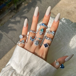 Close-up of S925 silver rings with blue heart and butterfly zircon stones worn on hand