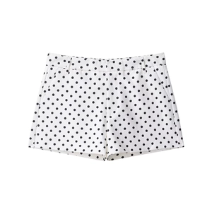 Dettaglio di pantaloncini a pois bianchi e neri con comode tasche laterali e passanti per cintura