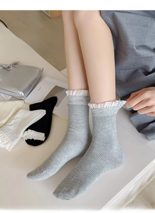 Détail de chaussettes grises style ballet avec bordure en dentelle blanche et élasticité