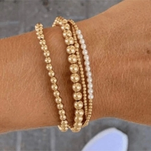 Elegant gold bead and white pearl layered bracelet set for women on wrist