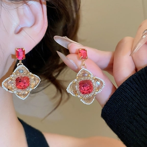 Detail of vintage French red crystal and pearl earrings with golden floral embossing