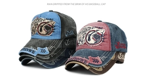Detailed embroidery of shark and anchor logos on distressed cotton canvas baseball caps