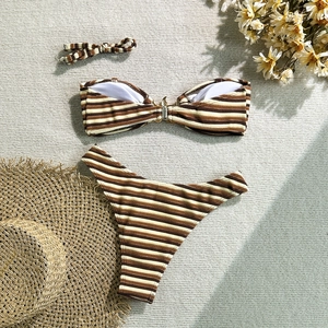 Detailed flat lay of striped bikini set with gold buckle and ribbed fabric texture