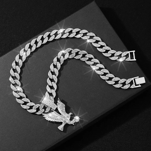 Close-up of a silver iced-out eagle pendant on a Cuban link chain with diamonds