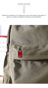 Detailed enamel pin featuring sriracha sauce design attached to a green canvas backpack