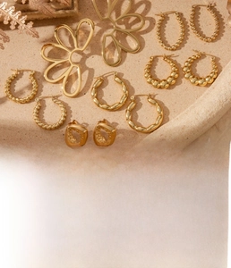 Detail of gold titanium steel earrings with vacuum plating process and flower textures