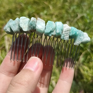 Detailed view of handmade silver hair comb with natural irregular light green crystals