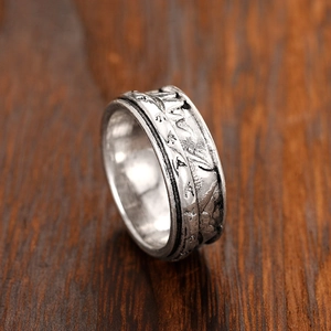 Macro detail of vintage silver ring featuring engraved mountain range and flying birds