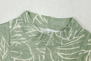Detail of sage green mesh fabric with white leaf prints and stand collar stitching