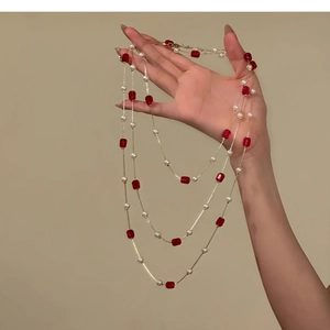 Elegant multi-layer necklace with white pearls and red crystal beads on gold chain