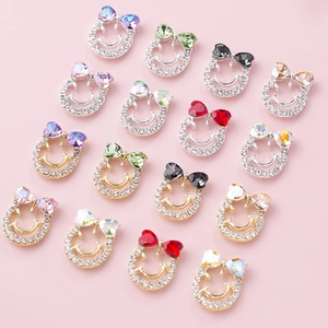 Bowknot smiley face nail charms with colorful crystals and rhinestones on pink background