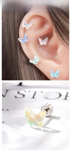 Vue macro de boucles d'oreilles papillon irisées avec texture d'opale et fermoir à vis