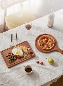 Top view of natural ebony wood rectangular serving tray and round pizza board with handle