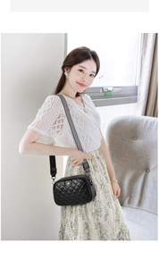 Detail of quilted leather crossbody bag featuring stylish black and white wide strap