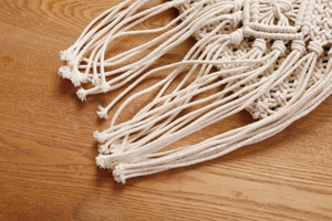 Detail einer böhmischen Makramee-Tasche mit Rautenmuster-Knoten und langen Fransen
