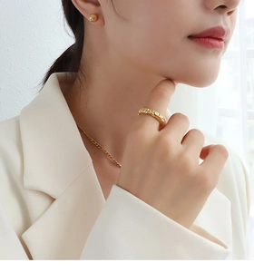 Vue détaillée de la bague martelée dorée et des boucles d'oreilles boules sur un mannequin