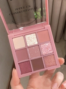 Close-up of nine-color eyeshadow palette with pink and earth tones in matte finish