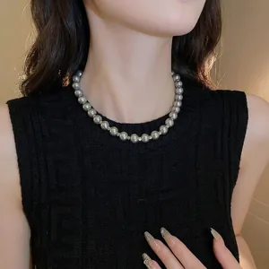 Elegant grey pearl necklace with polished silver spacers on a chic black knit top