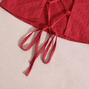 Dettaglio del top a fionda rosso con tessuto a righe e finitura con lacci sul bordo inferiore
