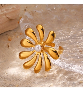 Detailed shot of an 18K gold-plated flower ring with a pearl inlay on a textured prop