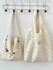 Sac à main en dentelle blanche avec bandoulière perlée et étiquette tissée