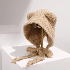 Detailansicht der beigefarbenen Plüschmütze mit Bärenohren aus weichem Bouclé-Garn
