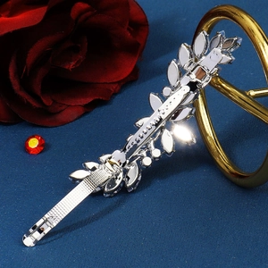 Macro view of silver leaf hair clip with zircon inlay on spring fastener