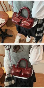 Close-up of dark red vintage saddle bag with glossy texture and twin front pockets