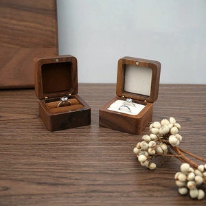 Macro shot of walnut wood ring boxes with dark and beige velvet lining for jewelry storage