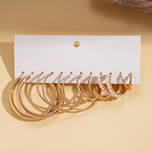 Detailed display of six pairs of gold-colored hoops with pearls and textured finishes